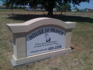 Sign for House of Prayer with contact details.