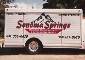 Sonoma Springs water delivery truck with contact information.