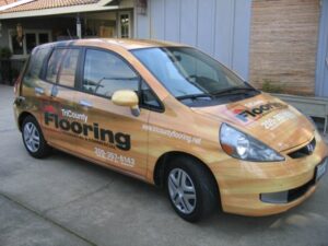 Car wrapped with TriCounty Flooring advertisement.